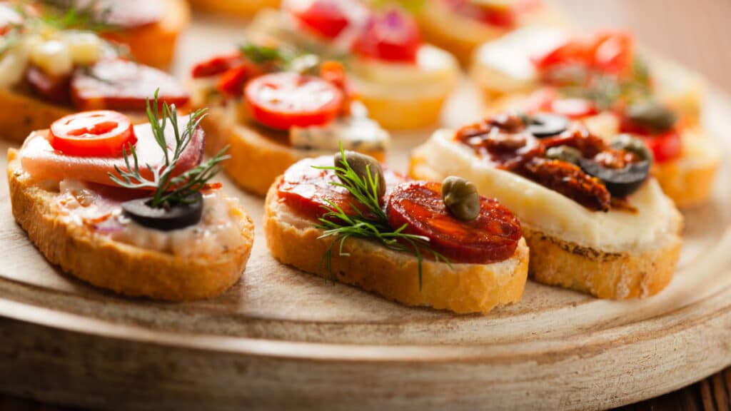 Crostini with different toppings on wooden background. Delicious appetizers. Front view.