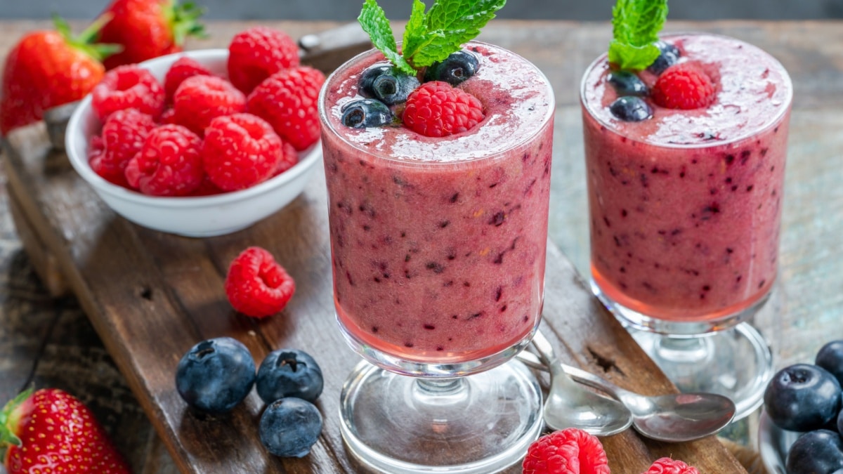 Mixed berry smoothie garnished with fresh fruit and mint