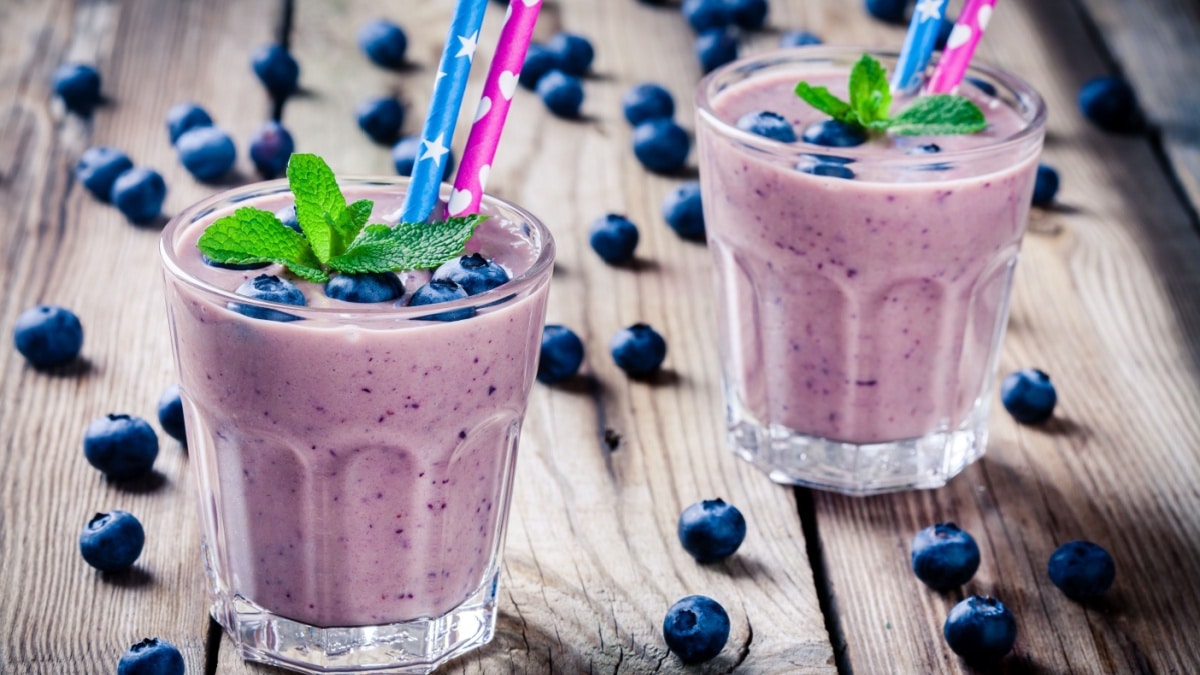 Blueberry smoothie in a glass on a rustic table